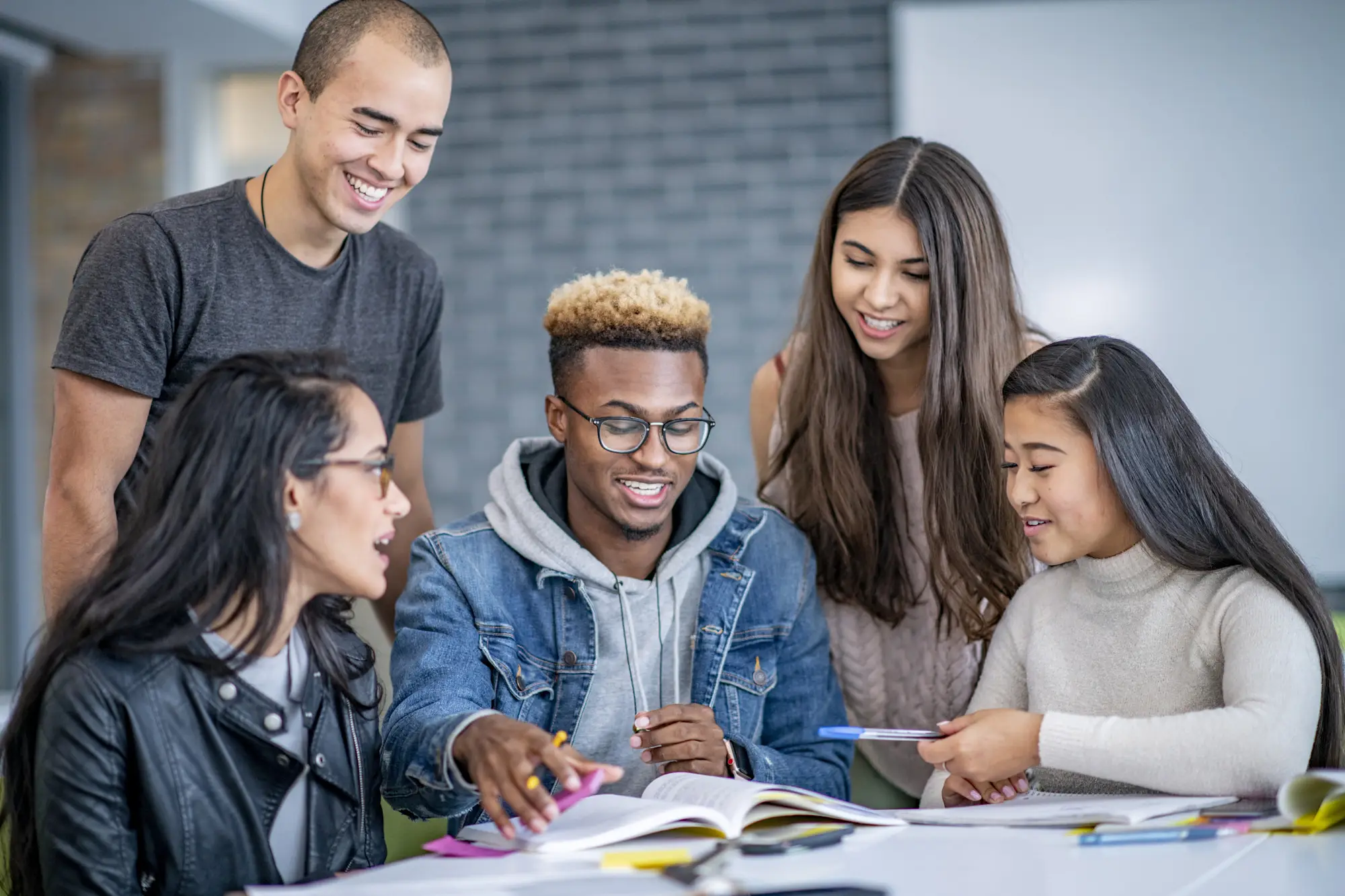 Smiling students collaborating around a table