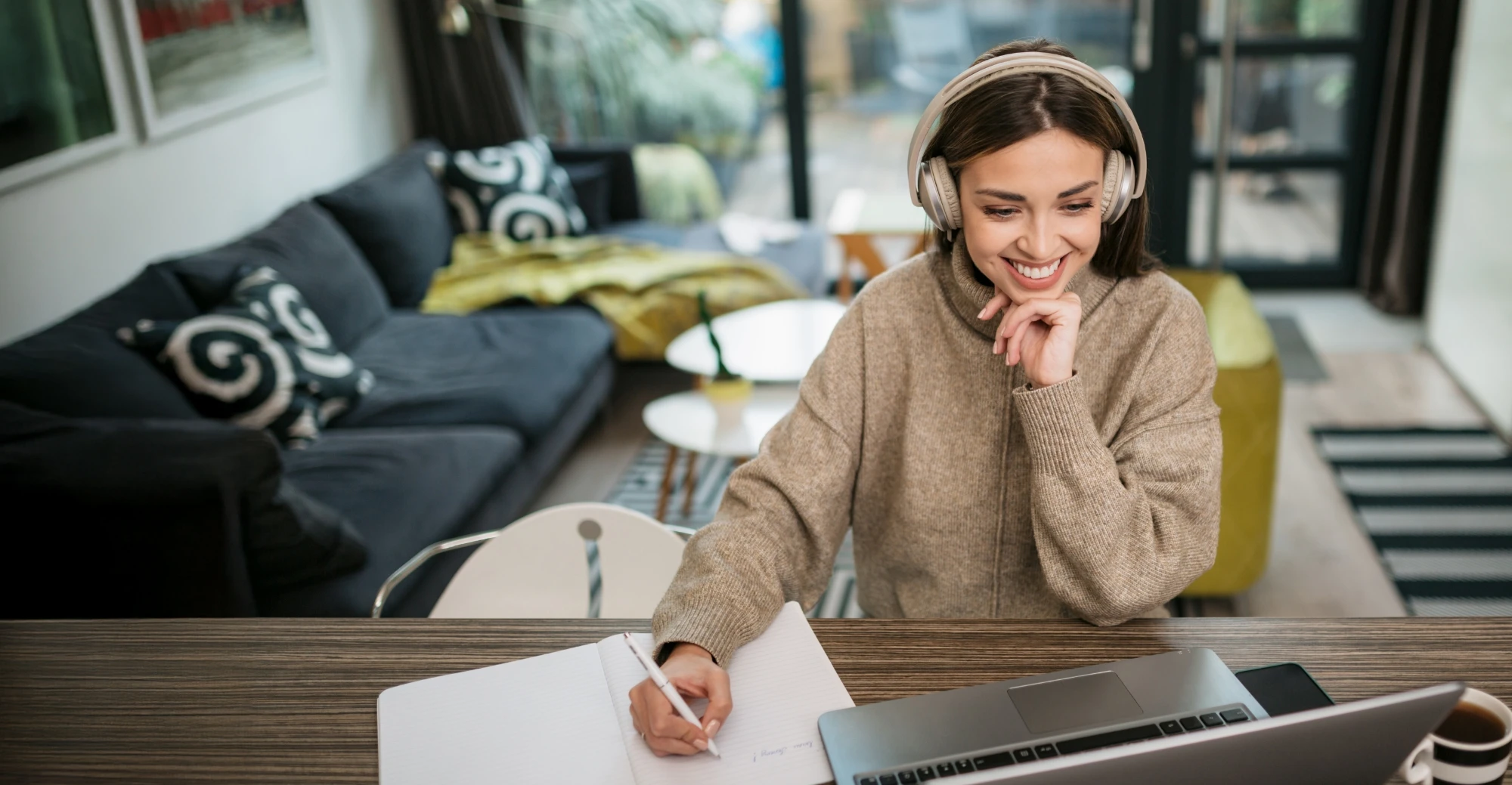 Smiling student at her laptop, wearing headphones
