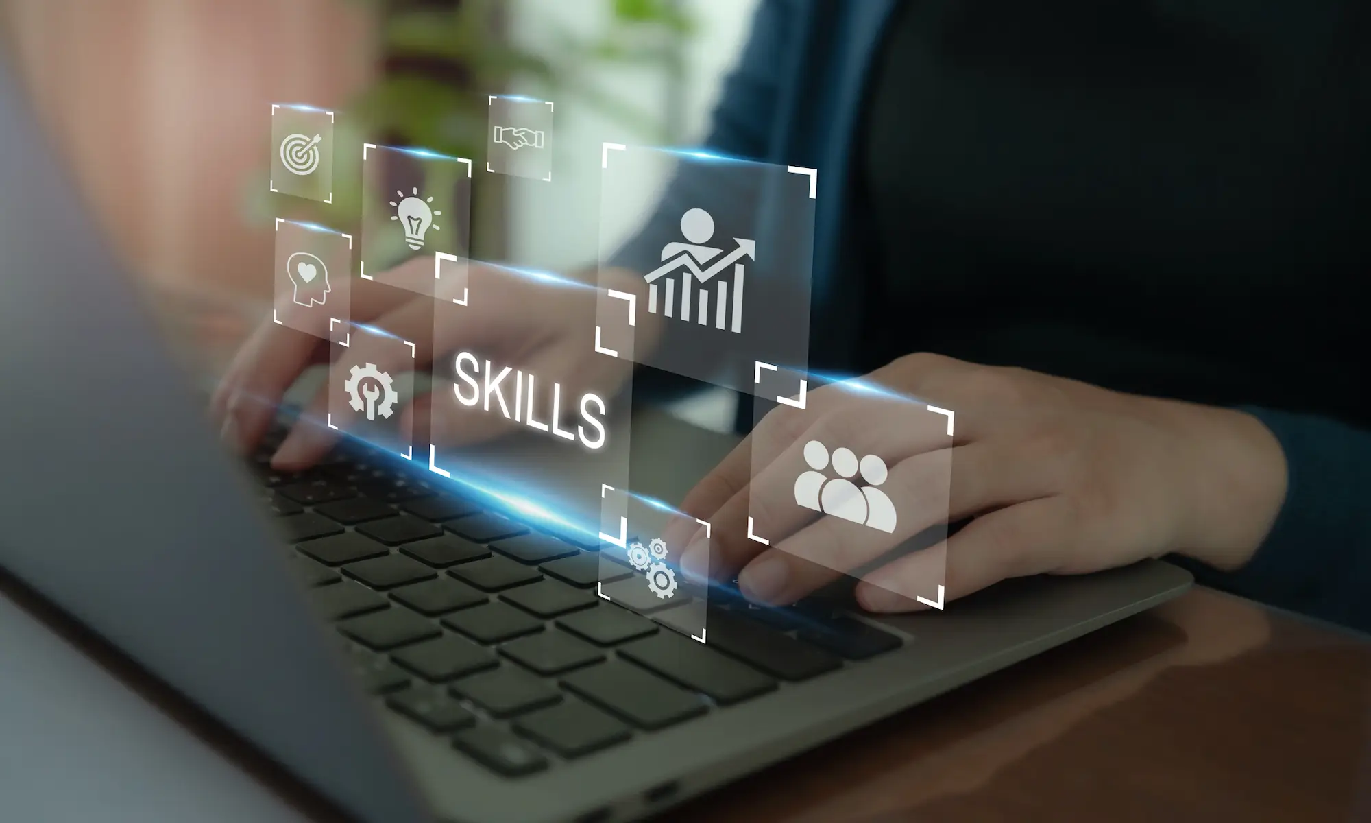 individual typing on a laptop with glowing icons popping up related to skills building