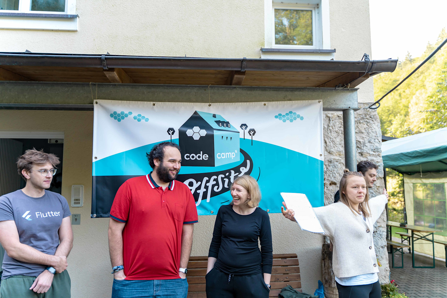 CodeCamper*innen vor dem Offsite 2021 Plakat.