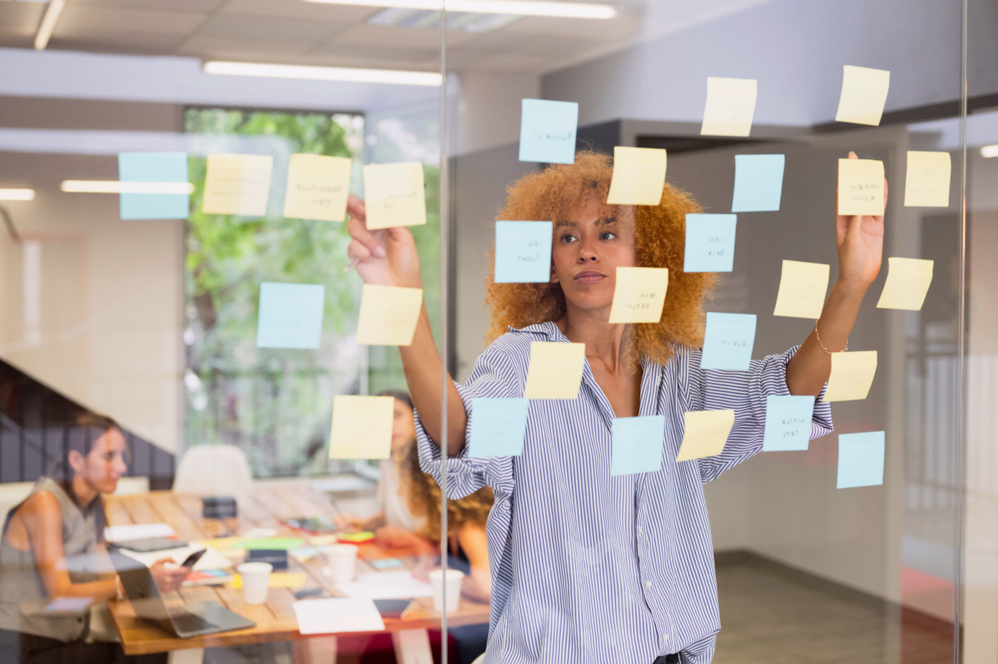 Team Brainstorming Session with Sticky Notes in Conference Room - stock image