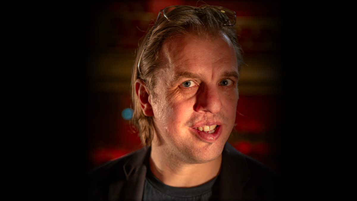 Jan Jaap van der Wal met zonnebril bovenop z'n hoofd kijkt recht de camera in.