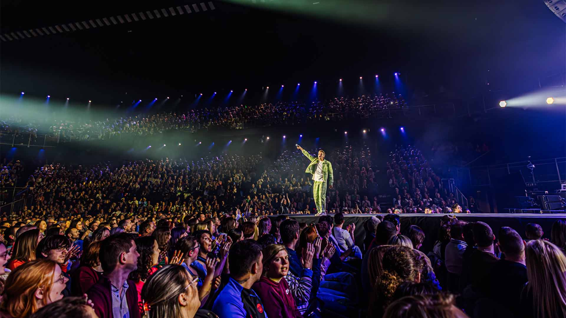 Jaap Reesema is standing on the catwalk in the middle of the Lotto Arena. He asks the fans to sing along.