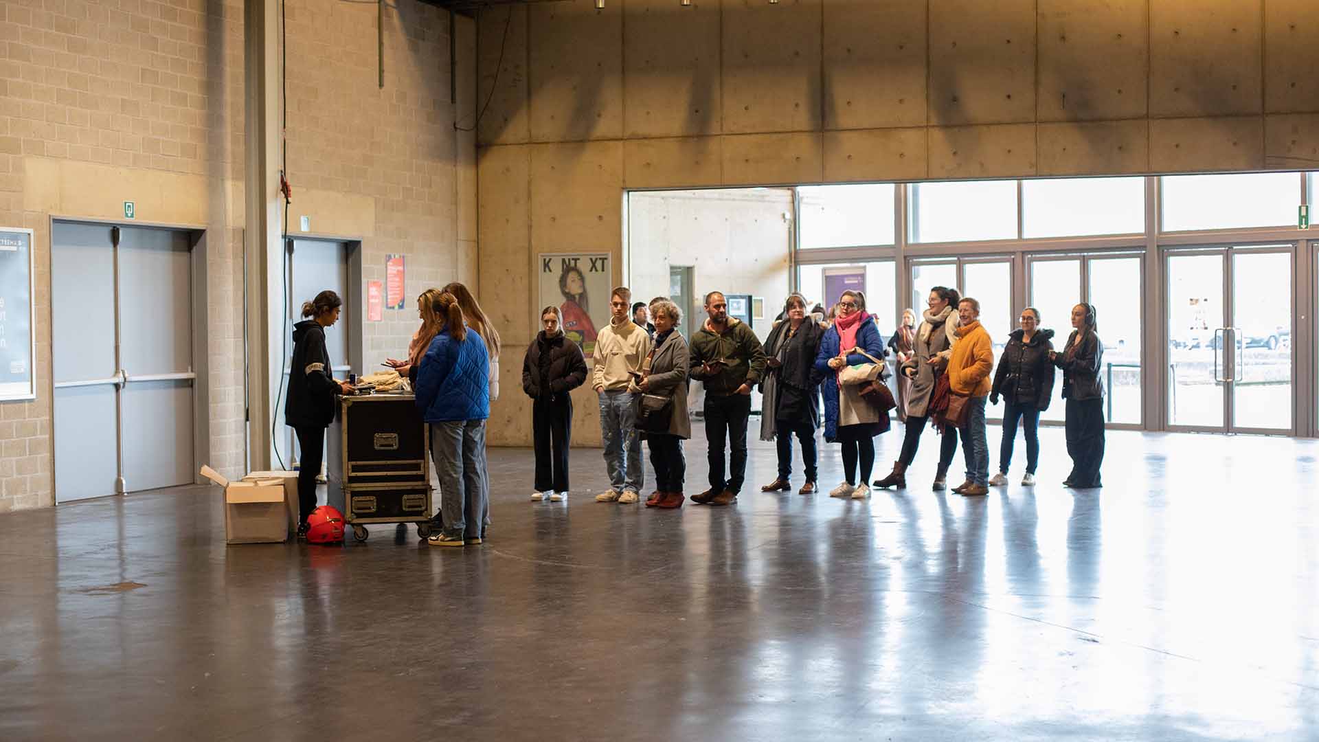 Een groepje mensen staat aan te schuiven aan de kassa in de inkomhal van de Trixxo Arena.