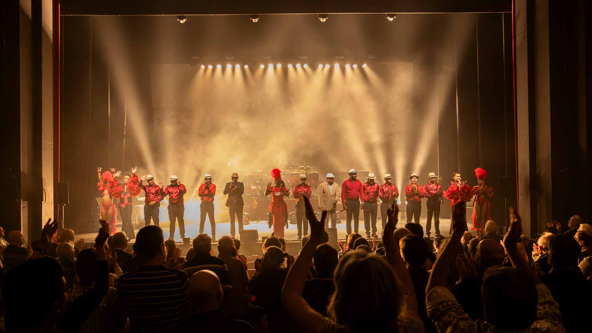 Op het podium groeten 16 mannelijke en vrouwelijke zangers, dansers en muzikanten van Pasión de Buena Vista het publiek na hun optreden. Ze krijgen een staande ovatie van het publiek. 2/2
