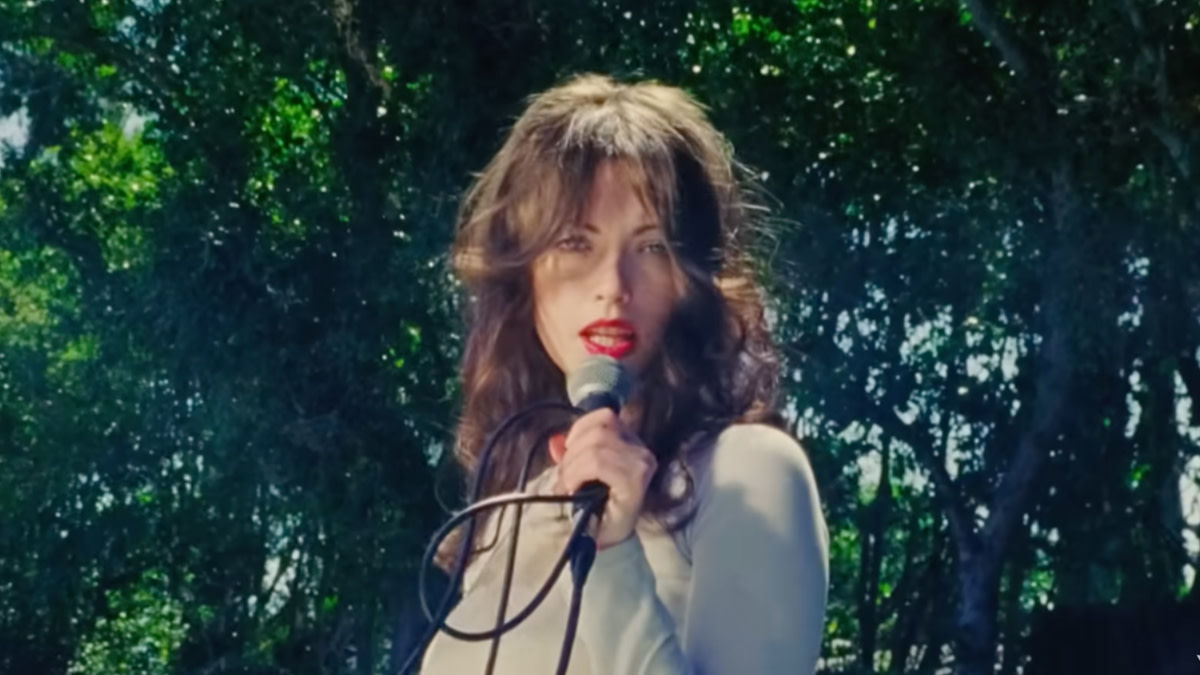 Violet Grohl met in de hand een microfoon in de videoclip bij de single 'Bug in the Cake'.