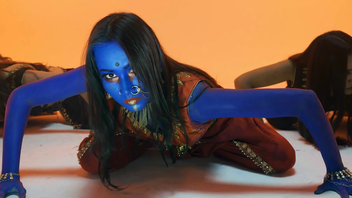 Still uit de videoclip Dana Dan van Bloodywood, met een performer met blauw beschilderde huid en traditionele Indiase sieraden.