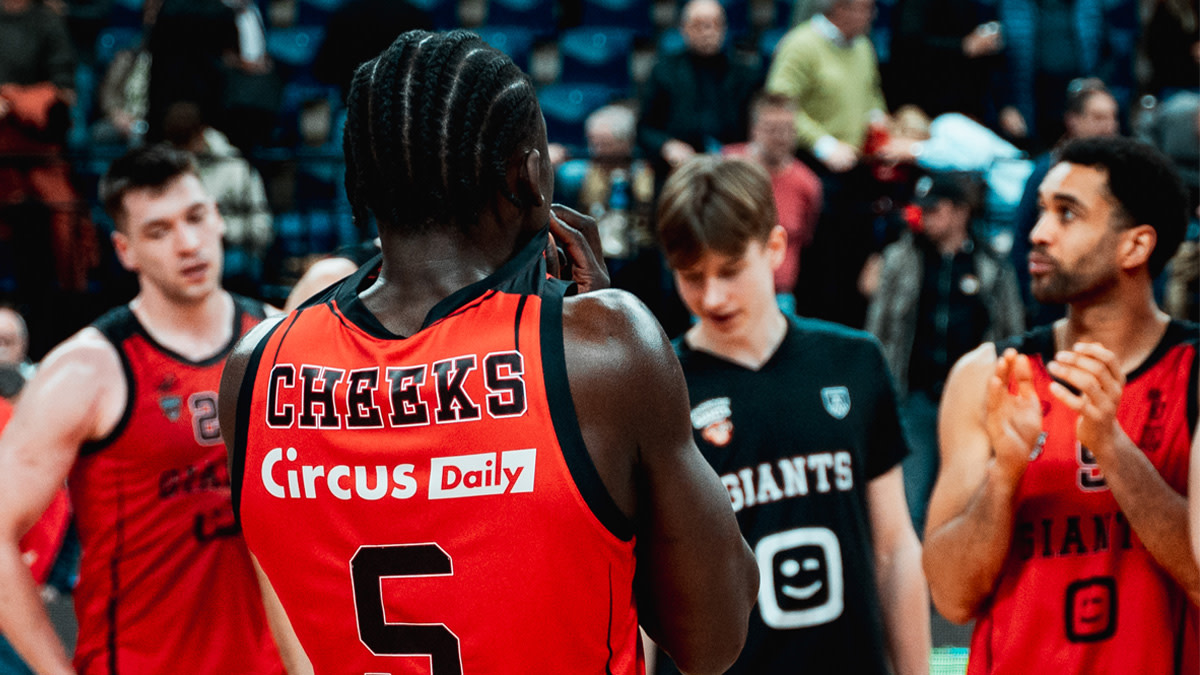 Enoch Cheeks op de rug gefotografeerd samen met drie Giants-spelers.