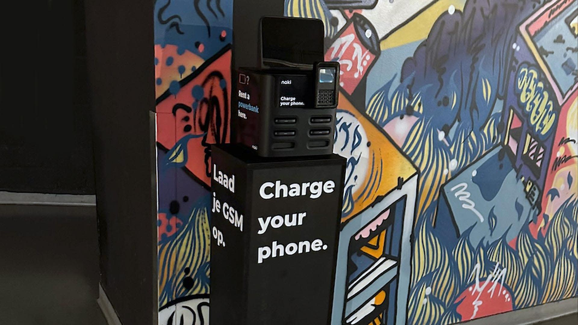 Naki device standing in front of a graffiti wall in Forest National.
