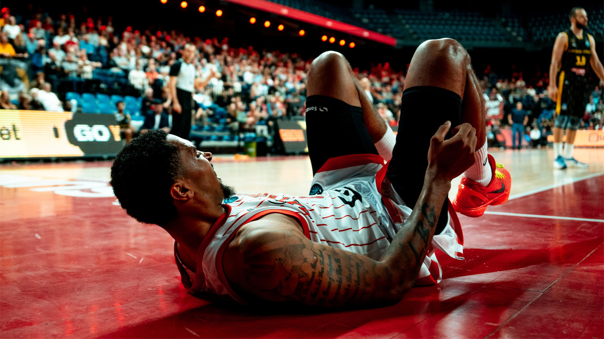 Een speler van de Antwerp Giants ligt op z'n rug op het basketveld na een actie.