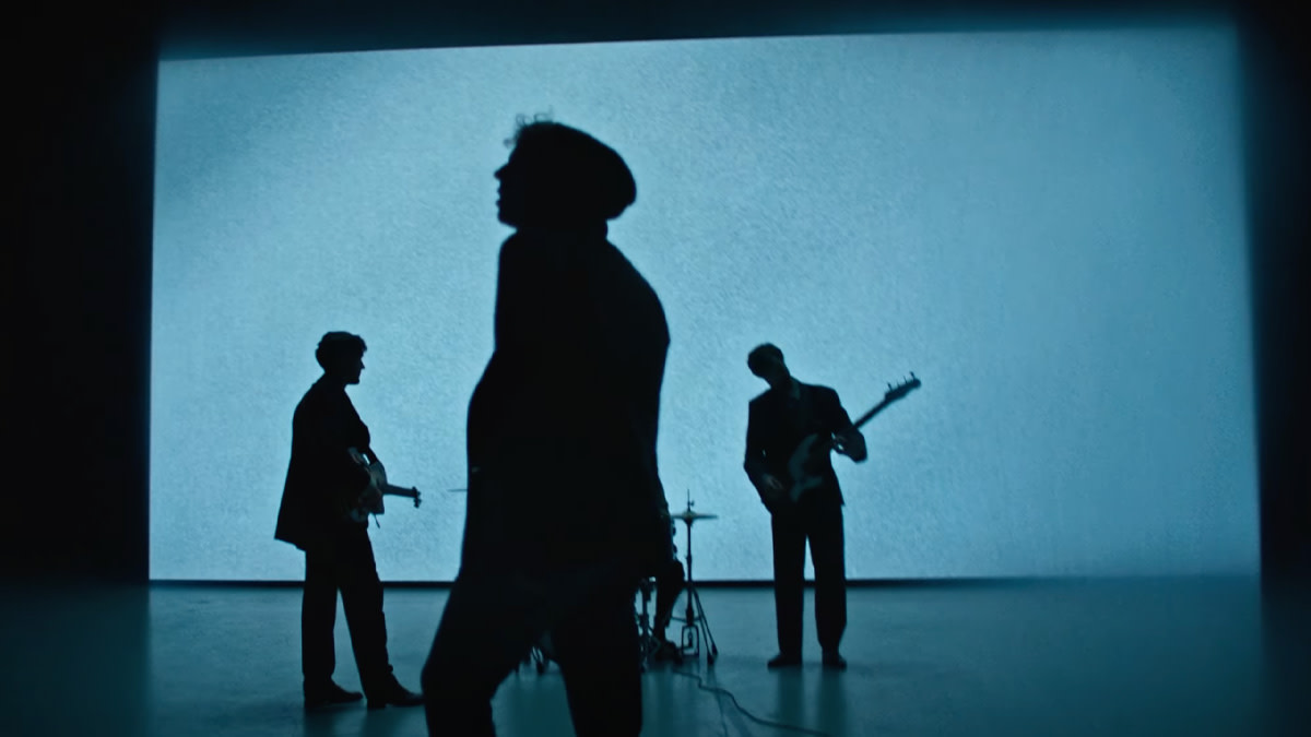 Tom Odell staat in de clip bij de single 'Ugly' voor een groot blauw, lichtgevend scherm.