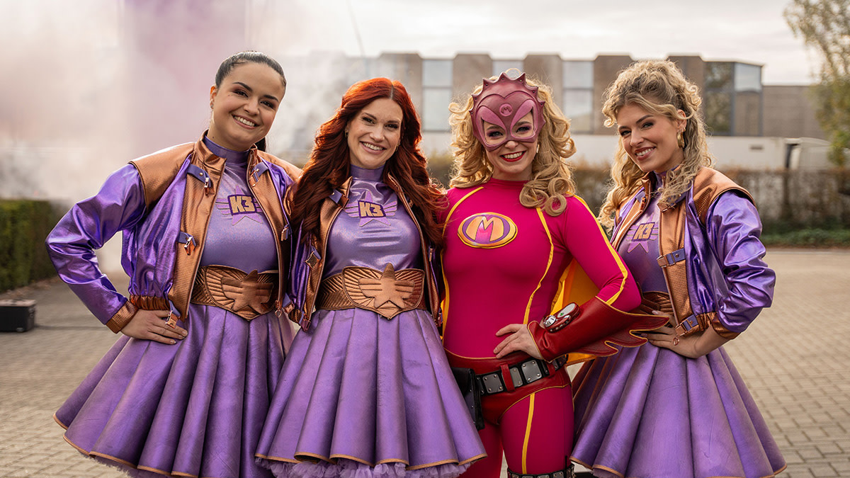 Marthe, Hanne en Julia in een paarse outfit samen met superheld Mega Mindy op de foto naa aanleiding van hun nieuwe theatertournee.