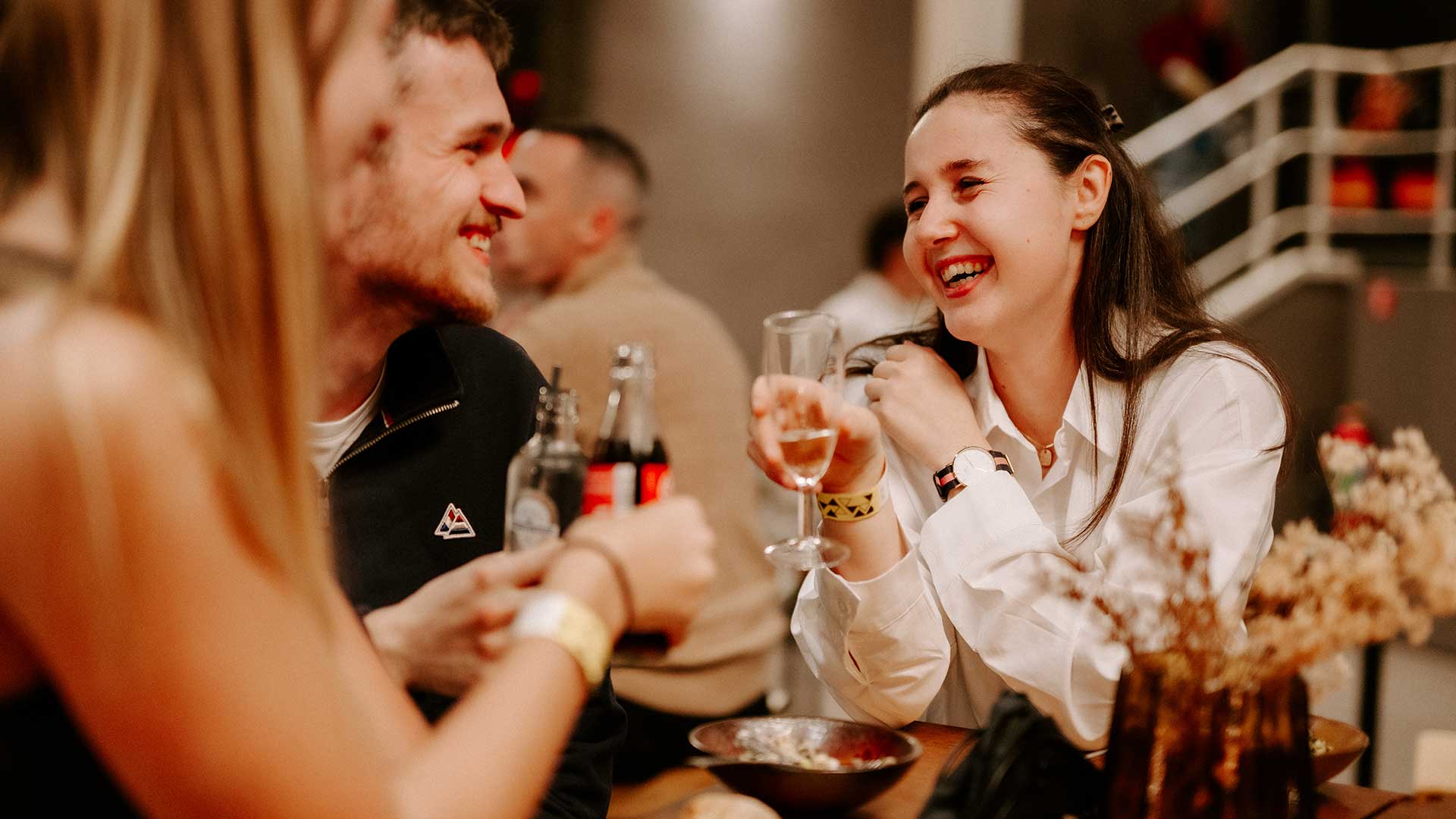 Lachende bezoekers proosten met champagne tijdens een Premium Experience diner