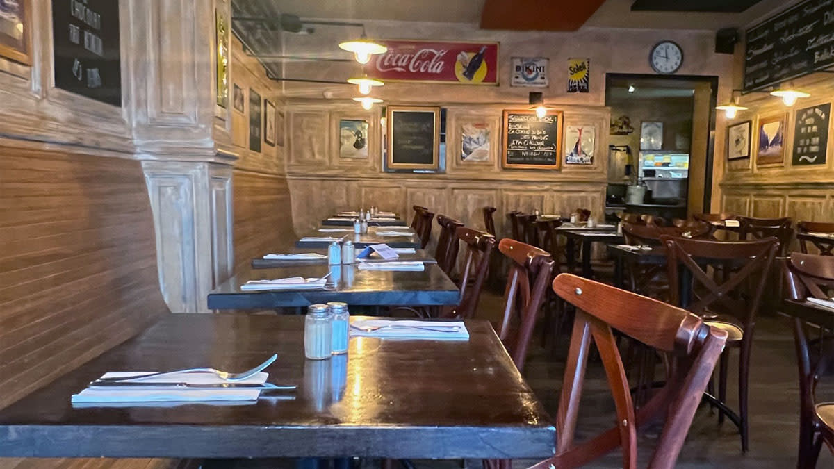 Gezellig interieur van restaurant Schieve Lavabo in Vorst, met houten tafels, boekenrekken en feestelijke versiering.