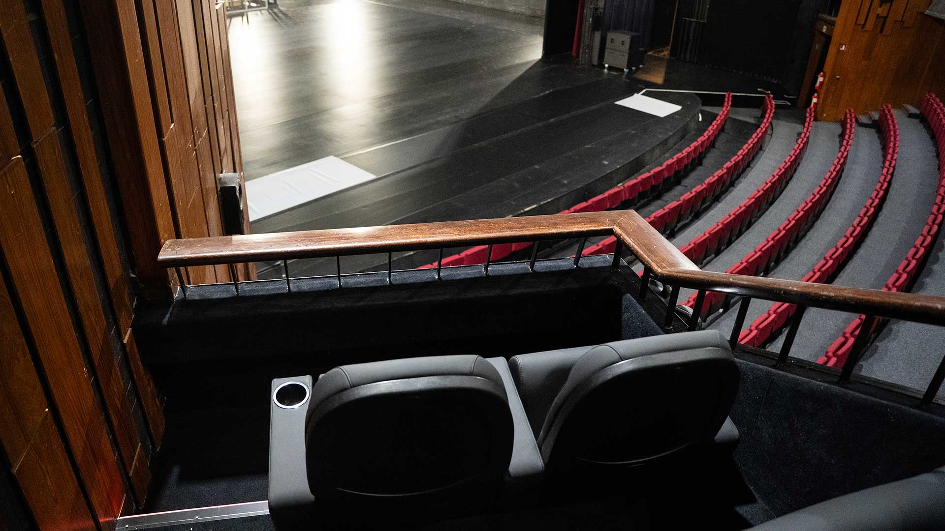 Uitzicht vanuit een theaterloge op rode zetels en het podium van Stadsschouwburg Antwerpen