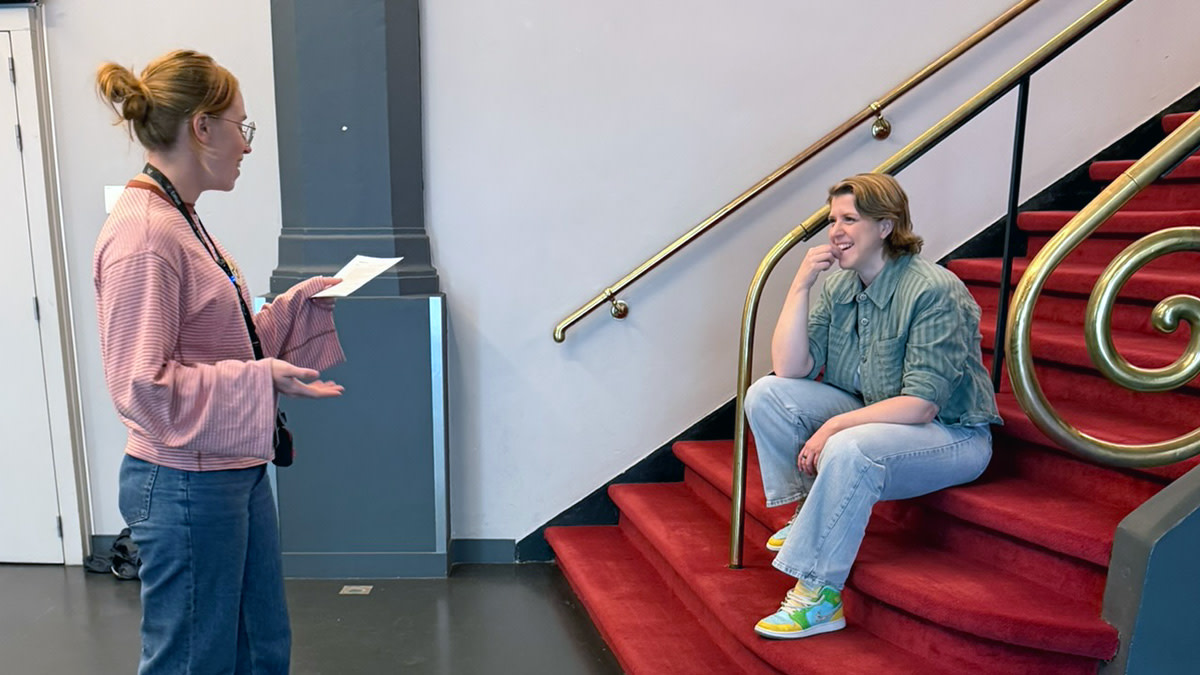 Onze collega Shary stelt quizvragen aan Hetty Helsmoortel die op de rood fluwelen trap van Capitole Gent zit.