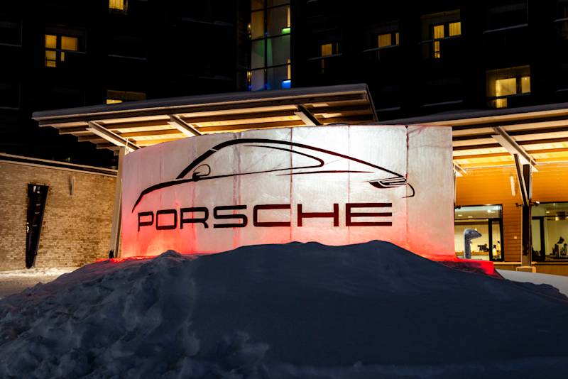 Ice sculpture with Porsche lettering and Porsche 911 silhouette at night in front of an illuminated building.
