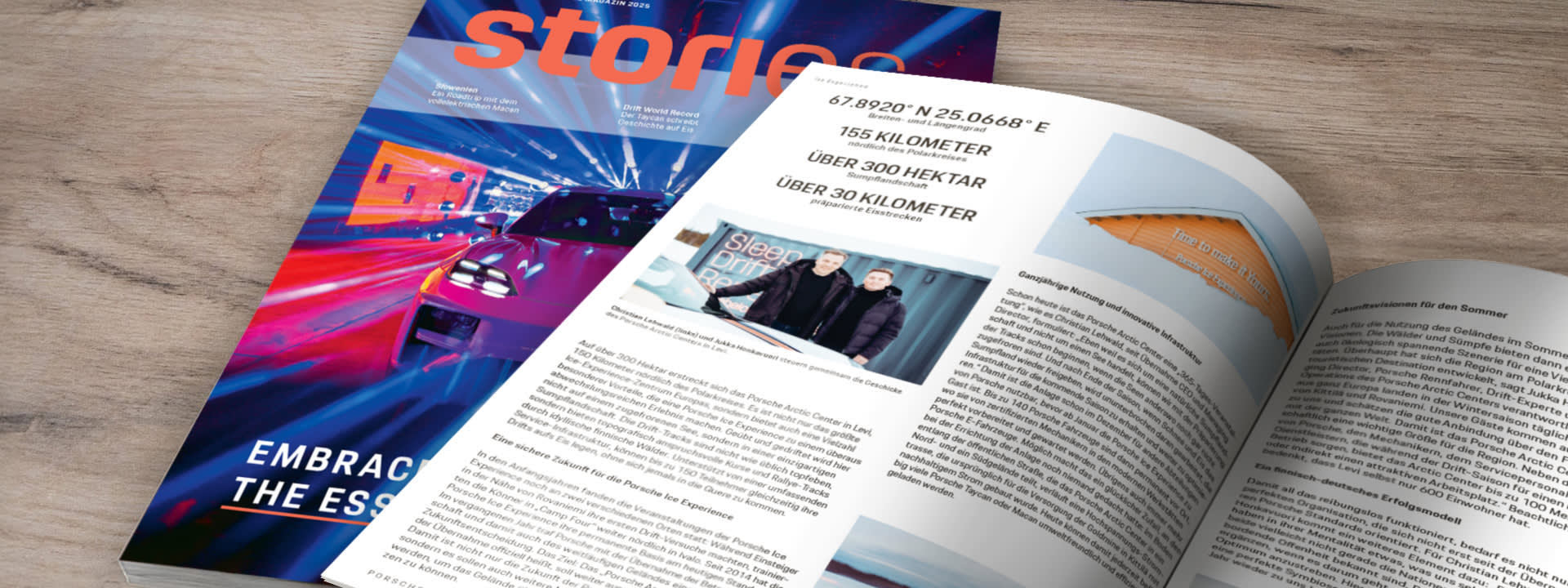 Printed Porsche stories magazine with cover and article spread about the Porsche Arctic Center on a wooden table.