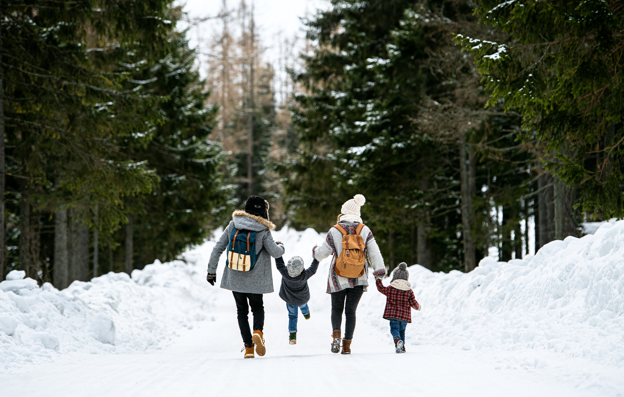 Family walking through the snow in winter