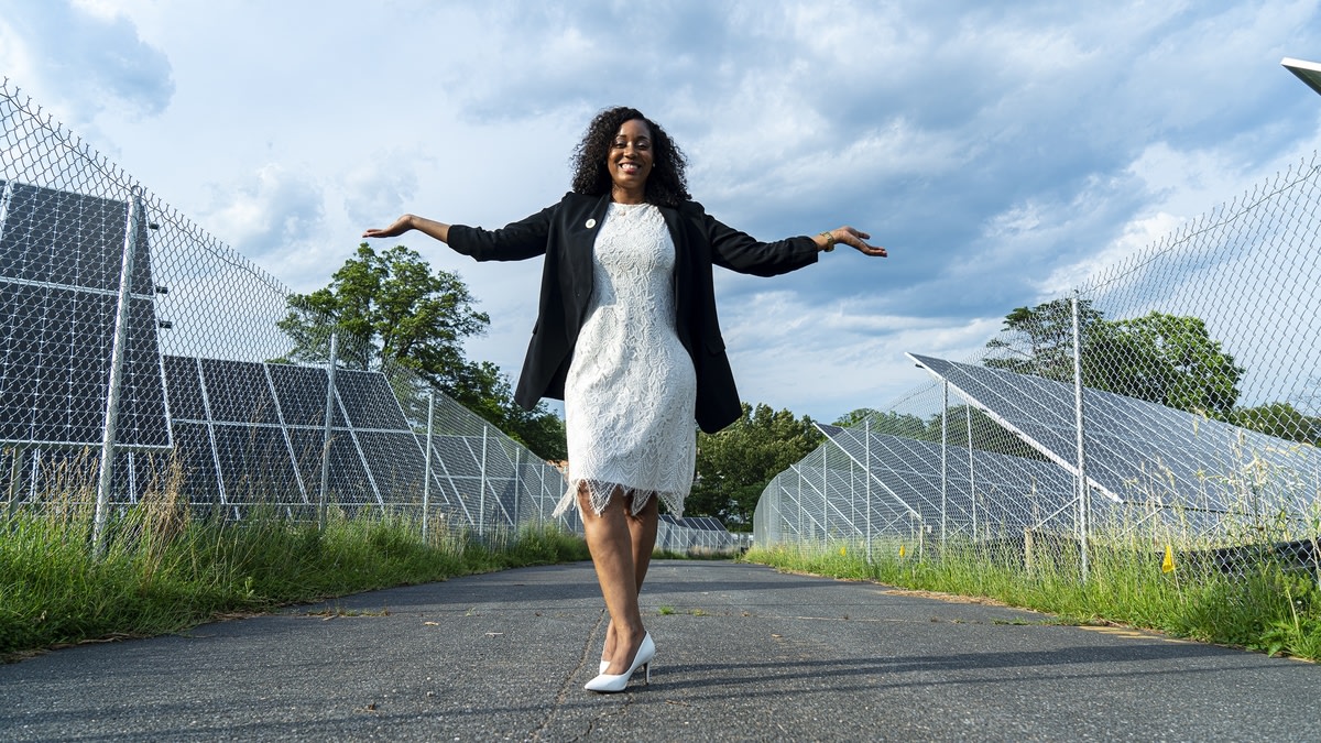 Kristal Hansley, CEO of WeSolar, standing in front of solar panels.