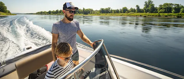 A man and child enjoying a boat ride on a lake.