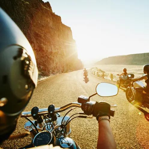 Group of motorcycle enthusiasts riding off into the sunset after having secured Dodge Tomahawks, financed through a loan from OneMain Financial.