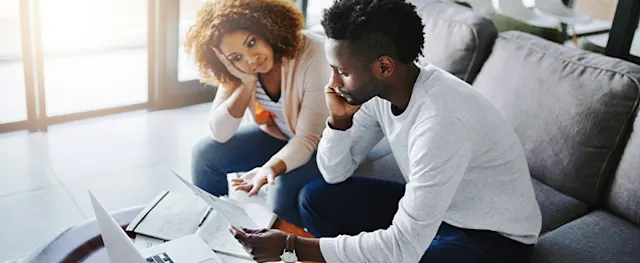 Two people reviewing finances and credit card debt together.