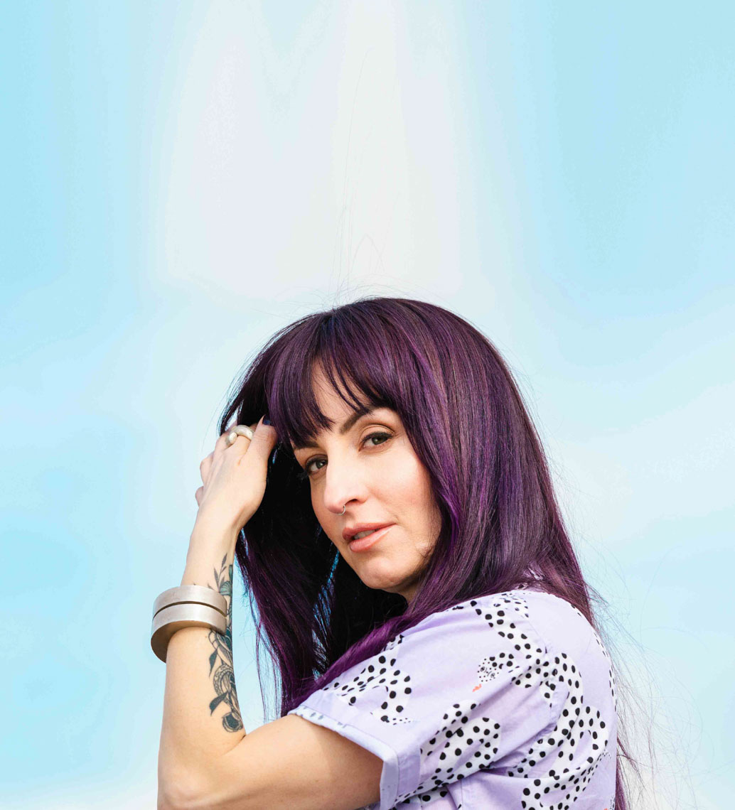 Person with purple for brown hair with a sky background
