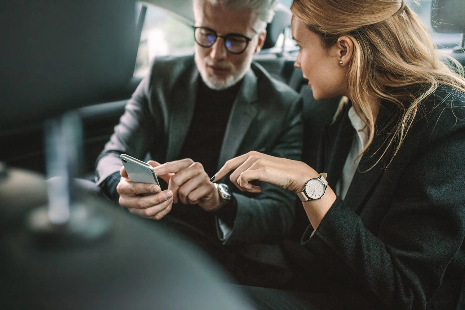Geschäftsleute benutzen ein Smartphone im Auto - 16:9