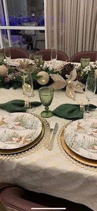 a dining table set with plates, glasses and flowers
