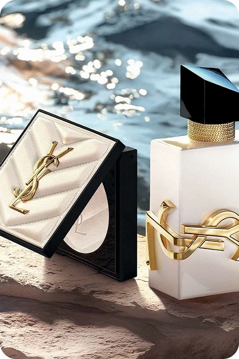 Boccetta di profumo YSL sulla pietra vicino al mare.