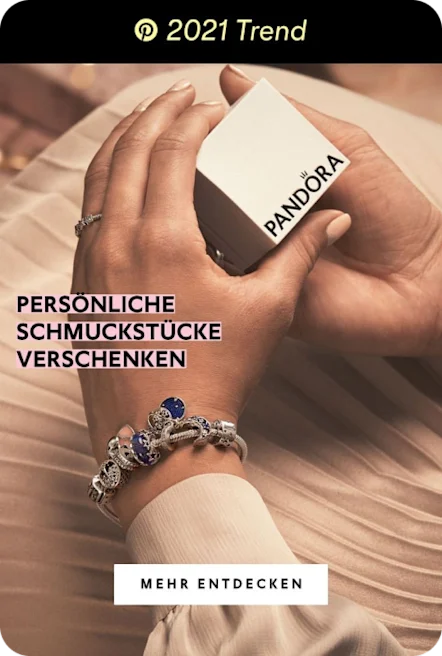 Person wearing pink skirt, white top, ring and bracelets holds white jewellery box