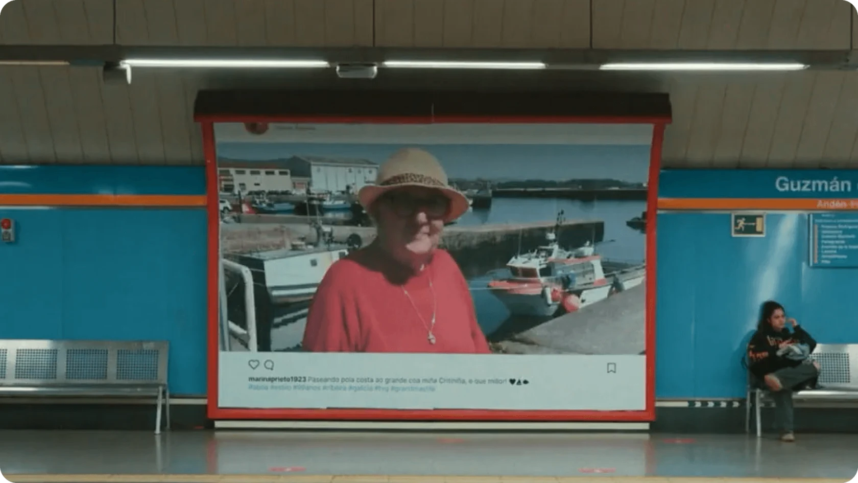 An ad at a transit station shows a social media post of an elderly woman posing by a dock.