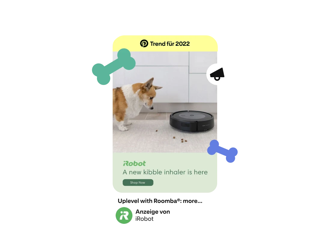 Pin-förmige Anzeige, die einen Corgi und einen Roomba-Saugroboter zeigt. Auf dem Boden liegt Hundefutter. Der Anzeigentext lautet: „A new kibble inhaler is here“. Darüber ist das iRobot-Logo zu sehen. Am oberen Rand prangt das „2022 Trend“-Badge. 