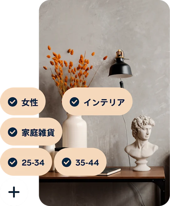 オレンジ色の花を生けた花瓶、黒いランプ、ミケランジェロのダビデ像の胸像が乗ったデスクのピンに、「女性」「インテリア」「インテリアグッズ」「25~34」「35~44」の検索キーワードが表示されている様子