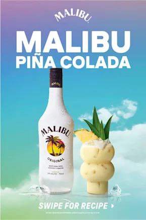 A bottle of Malibu Rum is set next to a frosty pina colada