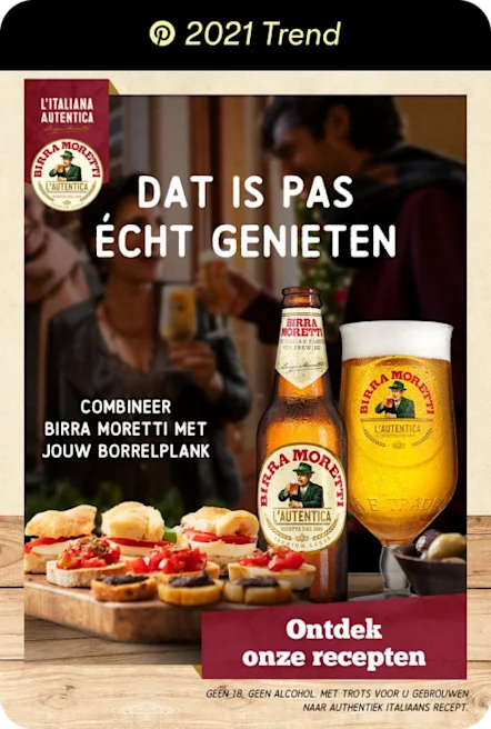 Bottle of beer and full glass on the table beside a tray of appetisers