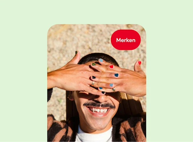 Eine lächelnde weiße Person hält sich die Hände vor die Augen; jeder Fingernagel hat eine andere Nagellackfarbe.