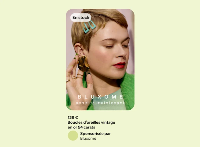 Une publicité sur un fond vert montrant une femme vêtue d’une veste verte et touchant une boucle d’oreille qu’elle porte du bout de ses doigts.