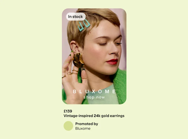 Advertisement on a green background showing a woman in a green jacket, delicately touching an earring she is wearing.