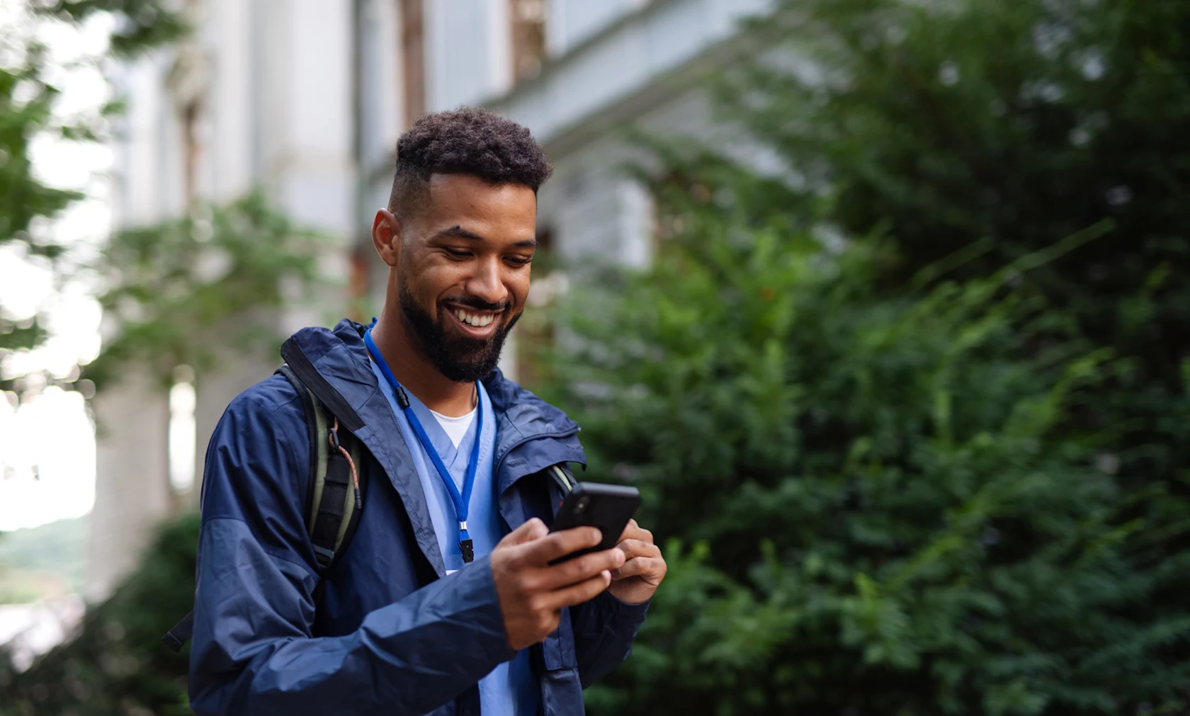 Young woman smiles as she scrolls on her smartphone