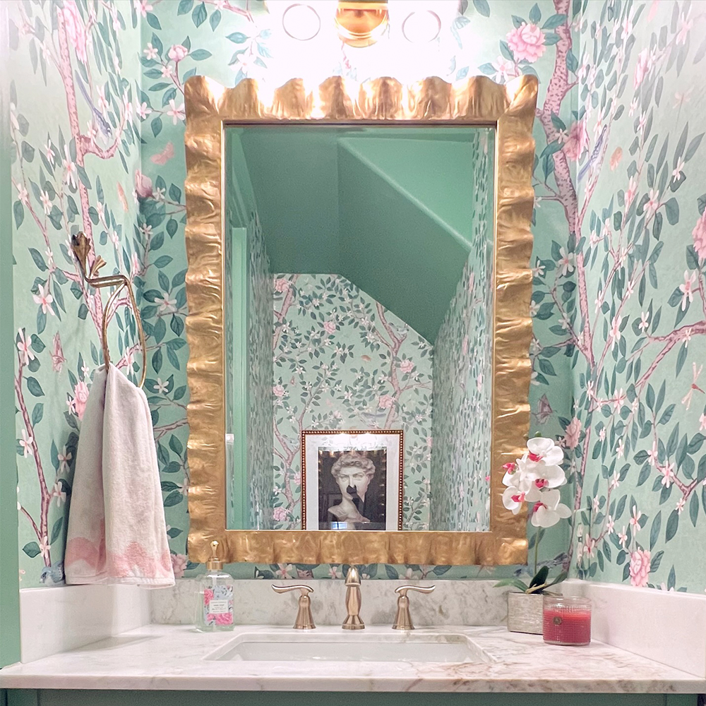 Bathroom with green branch and floral wallpaper.