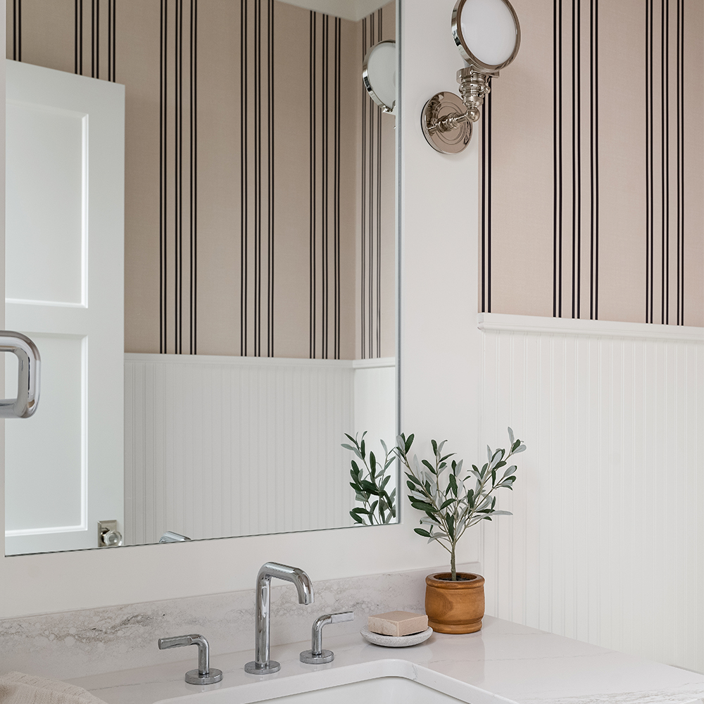 Bathroom with tan and black striped wallpaper.