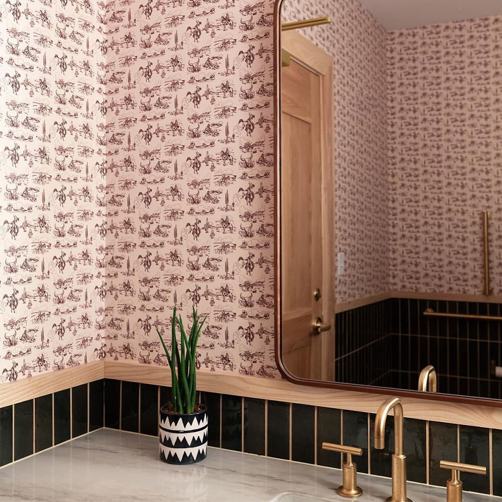 Bathroom with neutral cowboy toile wallpaper.