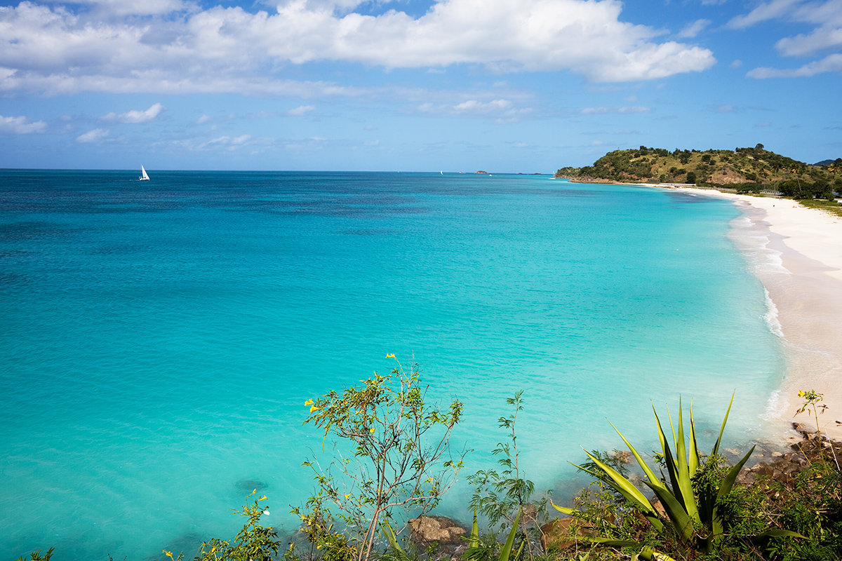 Turquoise waters of Darkwood Beach with sailboat in the background
