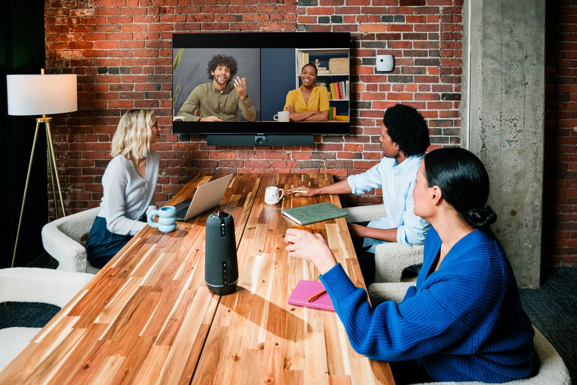 Team meeting around a table with a Meeting Owl 4+ and an Owl Bar