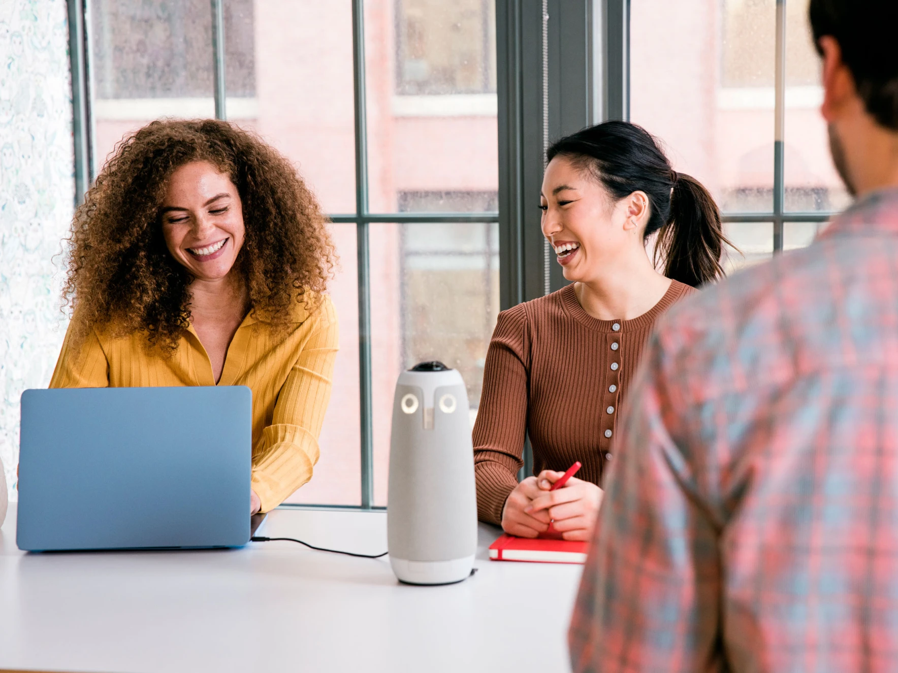 Colleagues enjoying a hybrid meeting with the Meeting Owl 3
