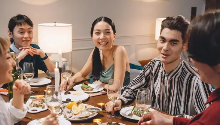 Adults gathered joyously around a table for a meal