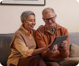 Older couple looking at tablet together while sitting on couch
