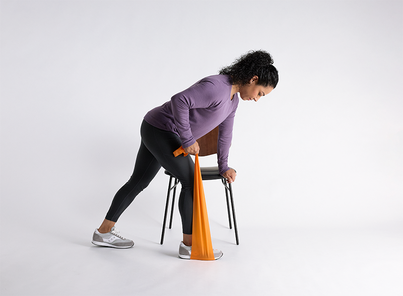 Woman doing Resistance band seated leg extensions exercise